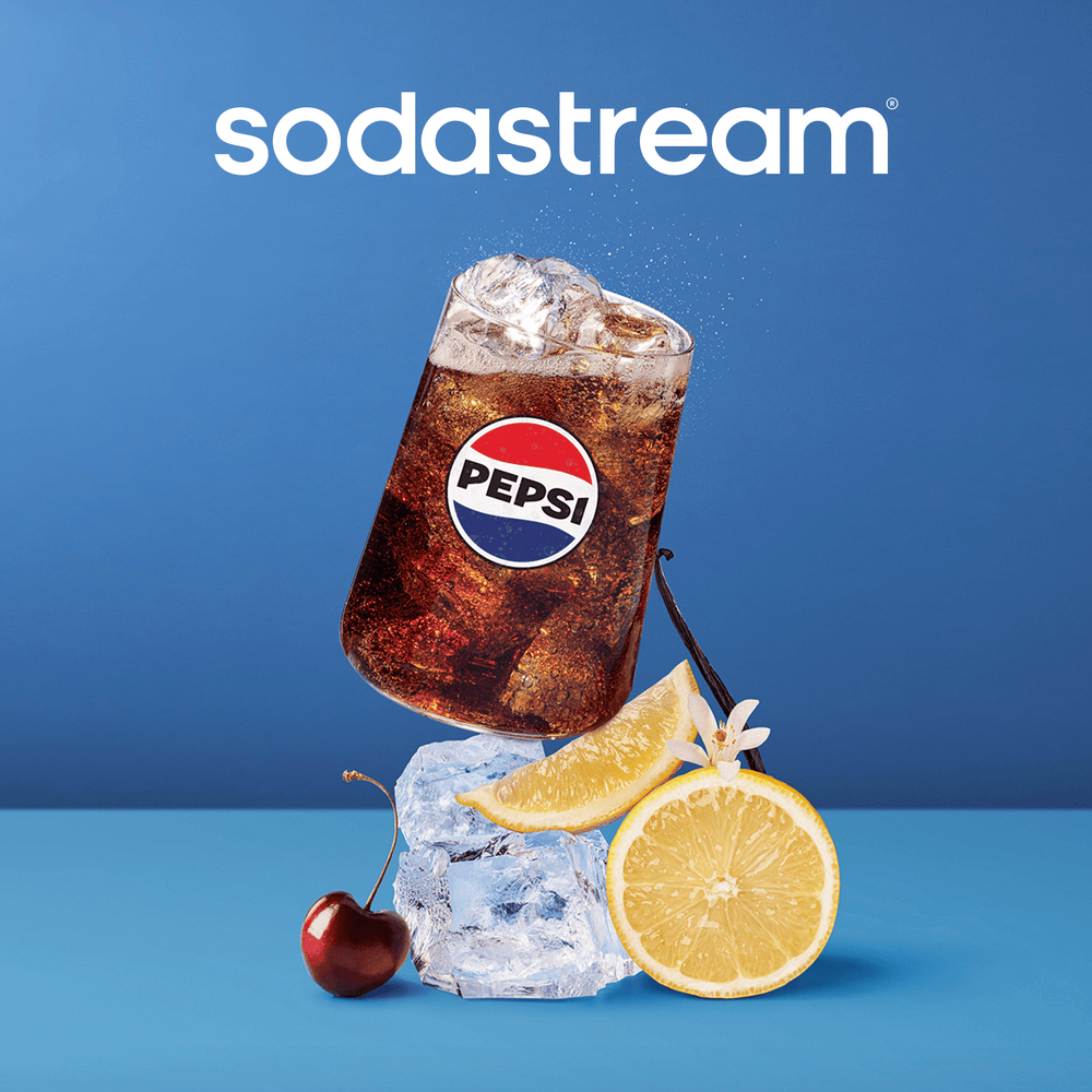 Sodastream Caffeine Free Diet Cola drink with lemon, cherry, and ice cubes on a blue background